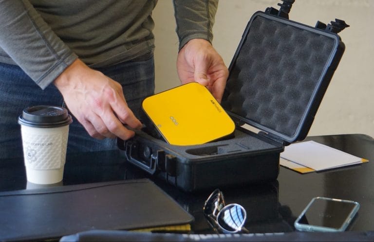 Person Setting Up Radon Testing Device on Table